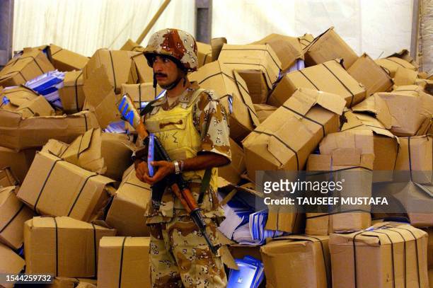 An Iraqi soldier guards boxes containing copies of the draft constitution that will later distributed to public in the city of Tikrit, north of...