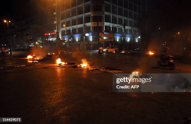 Tyres burn after being set on fire by Lebanese protesters in the northern city of Tripoli on October 19, 2012 to protest against the assassination of...