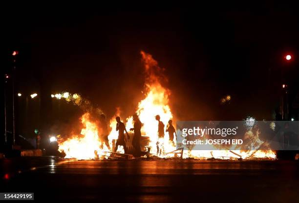 Lebanese men block a road leading to the airport in Beirut to protest against the assasination of top intelligence official Wissam al-Hassan in a...