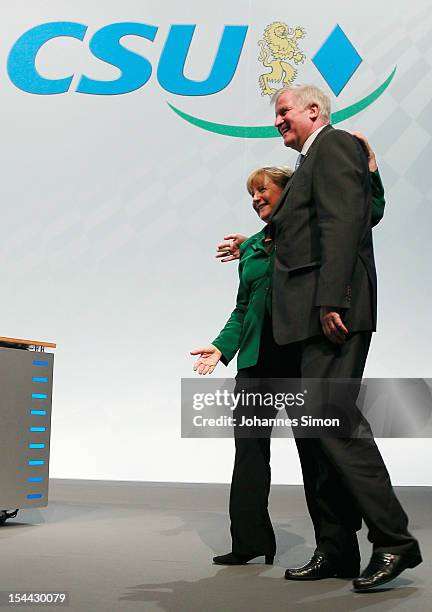 Horst Seehofer , Minister-President of Bavaria and chairman of the Christian Social Union of Bavaria , hugs German Chancellor Angela Merkel, who is...