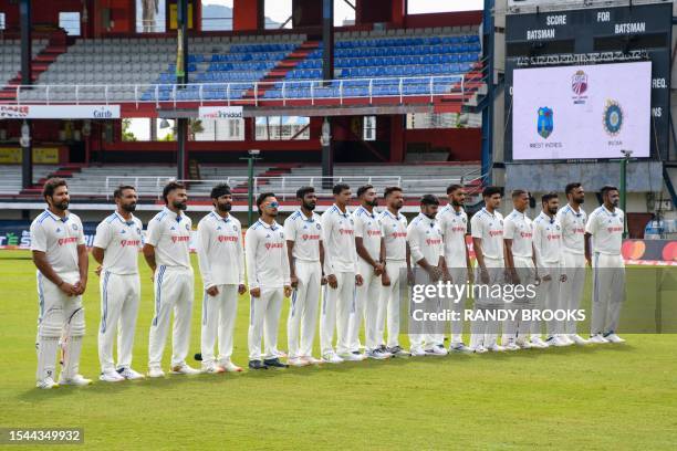 India players stand for the national anthem during the first day of the second Test cricket match between India and West Indies at Queen's Park Oval...
