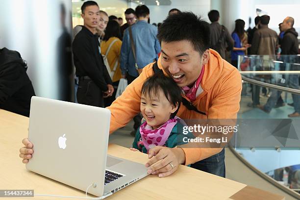 Chinese customers look at the MacBook Pro in the newly opened Apple Store in Wangfujing shopping district on October 20, 2012 in Beijing, China....