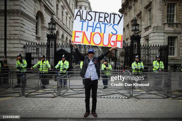 Man holds up a banner reading 'Austerity - That's Enough' outside outside Number 10 Downing Street during a TUC march in protest against the...