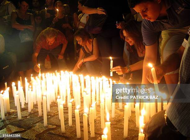 Lebanese light candles during a vigil in Beirut on October 20 near the site of a car bomb attack the day before in which Lebanon's slain police...