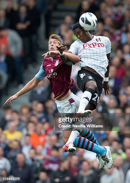 Nathan Baker of Aston Villa challenged by Hugo Rodallega of Fulham during the Barclays Premier League match between Fulham and Aston Villa at Craven...