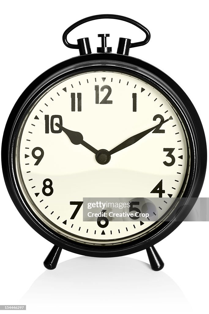 Old, black alarm clock showing 10.10am / pm