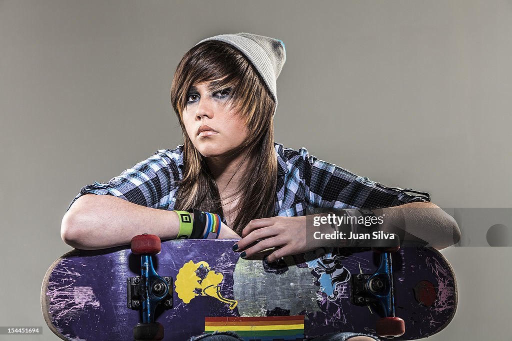 Portrait of teenage girl holding skateboard