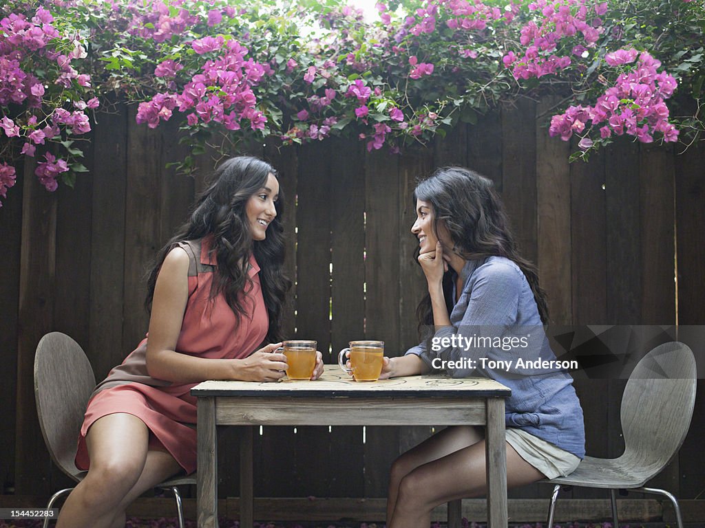 Two women having tea in back yard