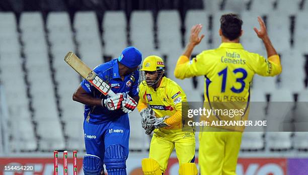 Mumbai Indians batsman Kieron Pollard looks back as Chennal Super Kings wicketkeeper MS Dhoni tries to stump him out and bowler Faf Du Plessis reacts...