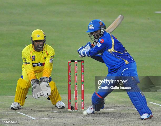 Harbhajan Singh of Mumbai about to hit a boundary with MS Dhoni looking on during the Karbonn Smart CLT20 match between Chennai Super Kings and...