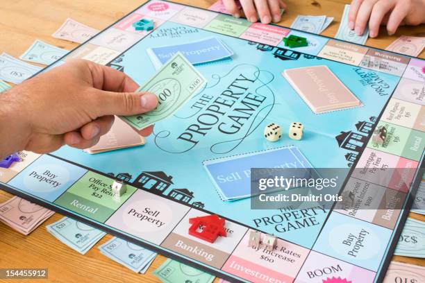 player exchanging money of property board game - board game stock pictures, royalty-free photos & images