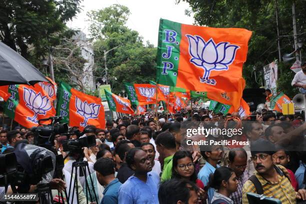 Activists hold party flags during a protest rally against the violence and deaths during the recently concluded West Bengal state local body...