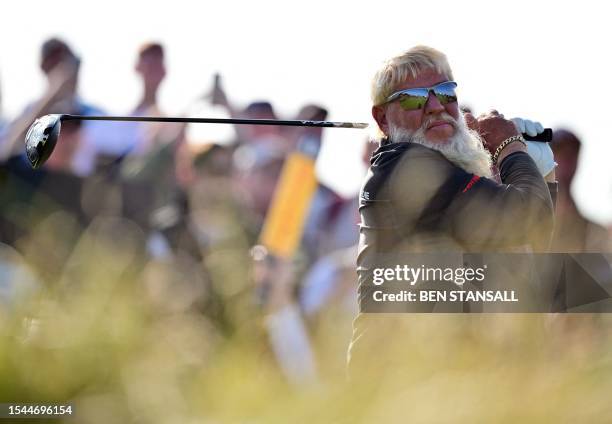 Golfer John Daly watches his drive from the 15th tee on day one of the 151st British Open Golf Championship at Royal Liverpool Golf Course in...