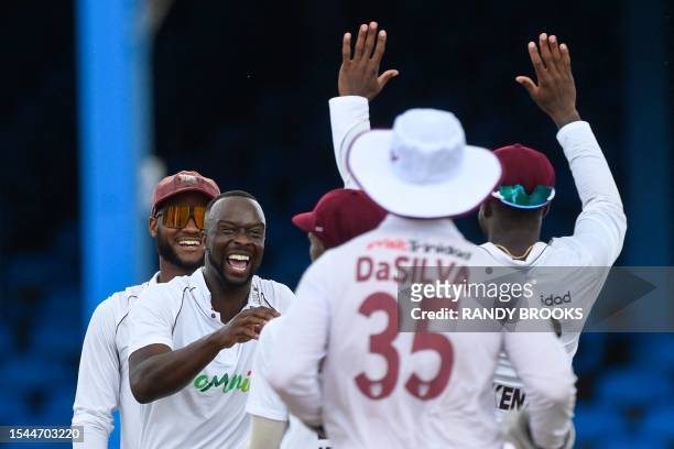 Kemar Roach and Kraigg Brathwaite , of West Indies, celebrate the dismissal of Shubman Gill, of India, on the first day of the second Test cricket...