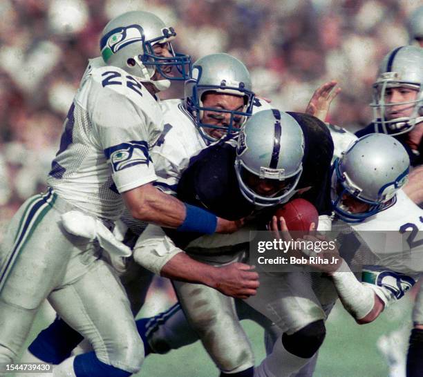 Los Angeles Raiders Running Back Marcus Allen runs to elude defenders during game action against Seattle Seahawks, December 15, 1985 in Los Angeles,...