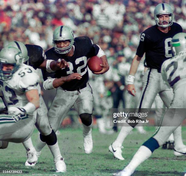 Los Angeles Raiders Running Back Marcus Allen runs to elude defenders during game action against Seattle Seahawks, December 15, 1985 in Los Angeles,...