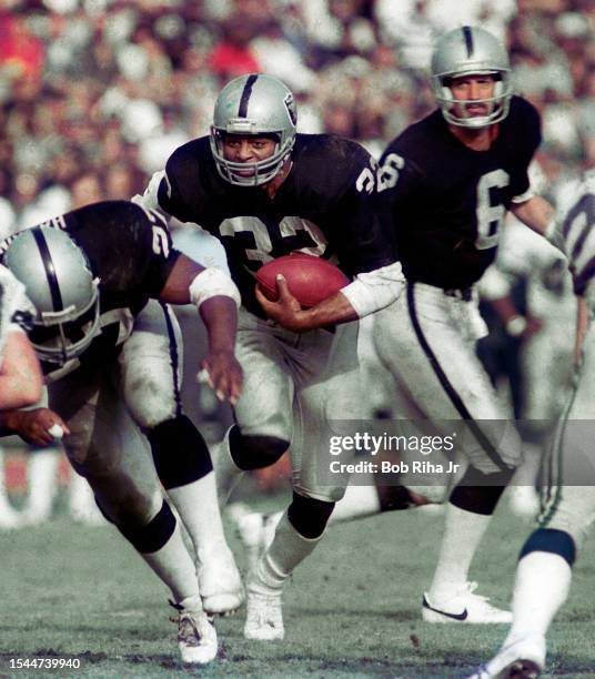 Los Angeles Raiders Running Back Marcus Allen runs to elude defenders during game action against Seattle Seahawks, December 15, 1985 in Los Angeles,...