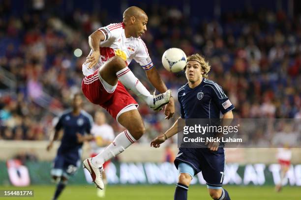Thierry Henry of the New York Red Bulls takes control of the ball in front of Chance Myers of the Sporting Kansas City at Red Bull Arena on October...