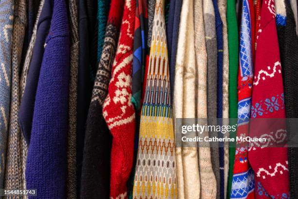 clothing rack of vintage sweaters at antique flea market - jumper stock pictures, royalty-free photos & images