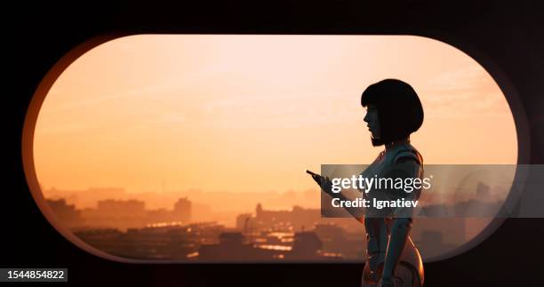 standing by the window, the cyborg girl holds a phone, her appearance a captivating blend of human and machine - 3d face stockfoto's en -beelden