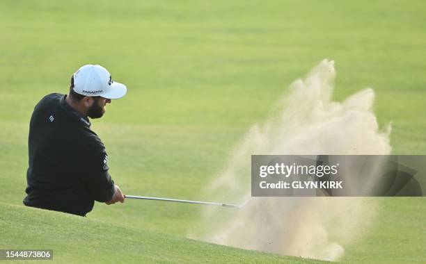 Spain's Jon Rahm plays out of a bunker onto the 18th green on day one of the 151st British Open Golf Championship at Royal Liverpool Golf Course in...