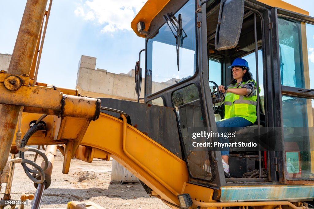 Bauarbeiterin, die mit Bagger arbeitet