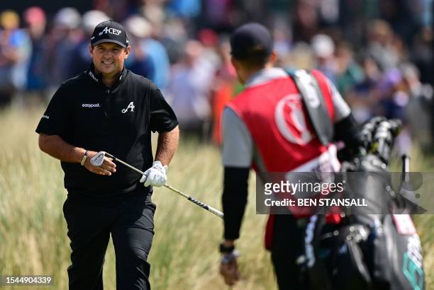 Golfer Patrick Reed walks to his caddie on the 17th on day one of the 151st British Open Golf Championship at Royal Liverpool Golf Course in Hoylake,...