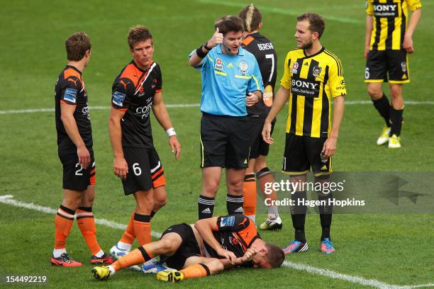 Jeremy Brockie of the Phoenix talks to referee Adam Kersey while Matthew Jurman of the Roar lies on the ground after taking a heavy tackle during the...