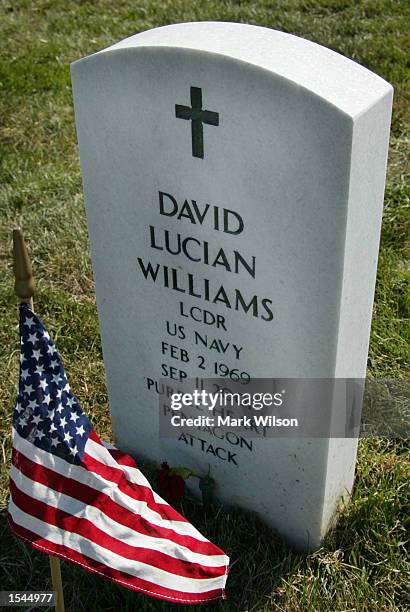 The gravestone of a victim of the Pentagon attack is shown with an American flag in front of it at Arlington Memorial Cemetery May 23, 2001 in...