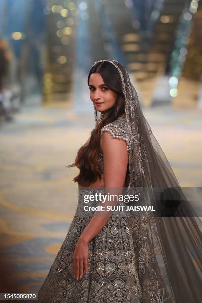 Bollywood British actor Alia Bhatt presents a creation by Indian fashion designer Manish Malhotra during 'The Bridal couture show' in Mumbai on July...