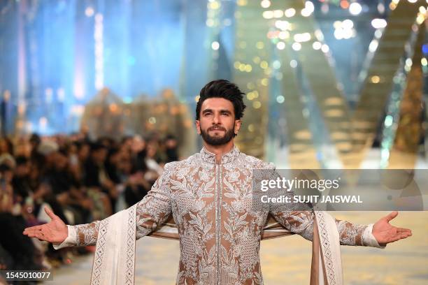Bollywood Indian actor Ranveer Singh presents a creation by Indian fashion designer Manish Malhotra during 'The Bridal couture show' in Mumbai on...