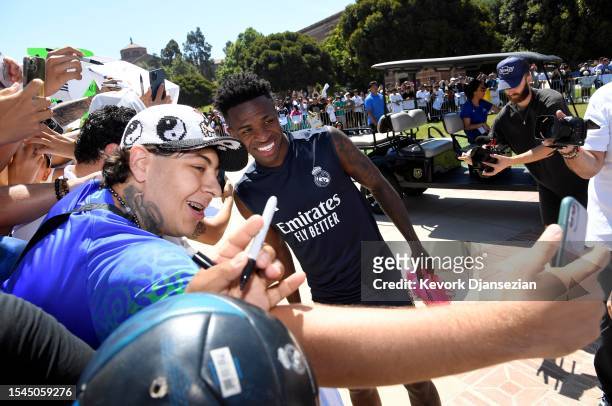 Vinicius Junior of Real Madrid poses for a selfie with Los Angeles fans as he arrives with teammates for training at UCLA Campus to kick-off their...