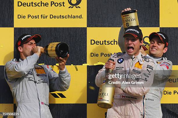 Bruno Spengler of Canada and BMW Team Schnitzer celebrates with second placed Gary Paffett of Great Britain and Thomas Sabo Mercedes AMG and third...