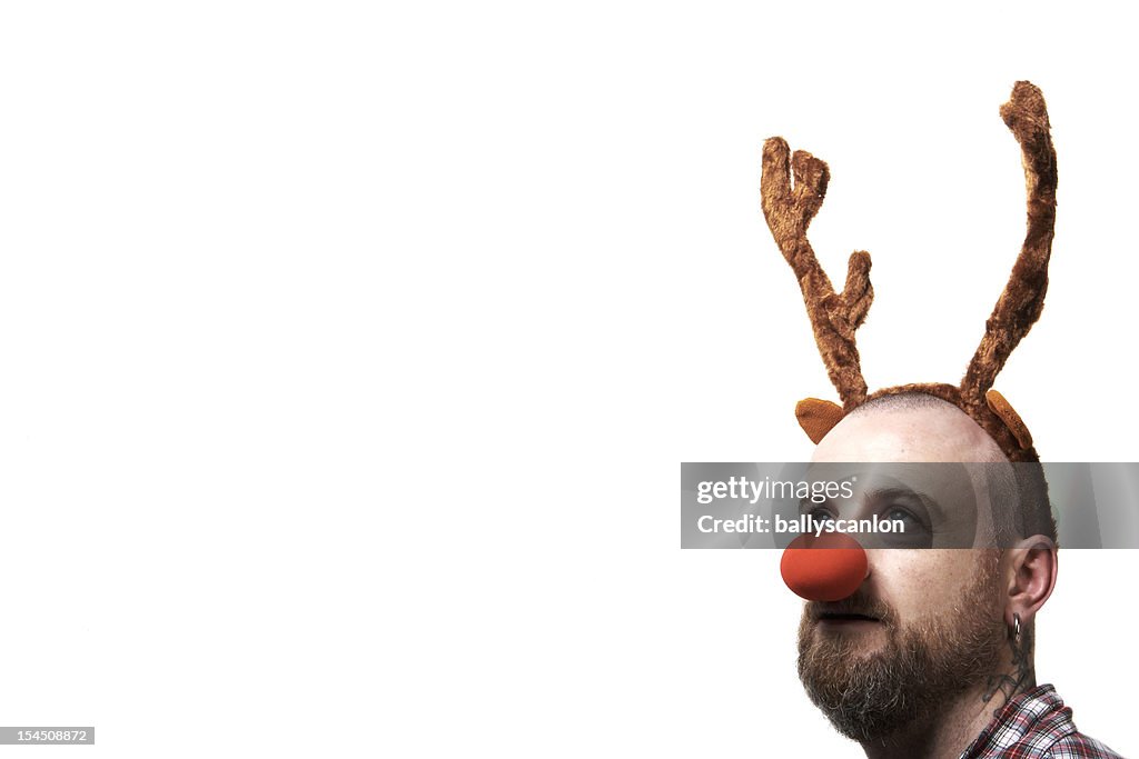 A man wearing reindeer antlers and a red nose