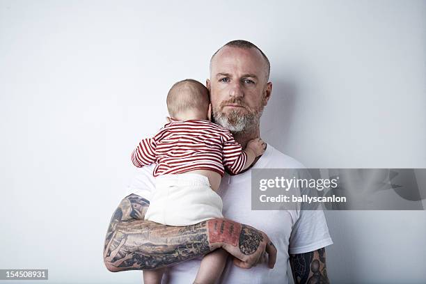 father holding child in arms. - babyhood photos et images de collection