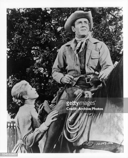 Betsy Palmer looks up to Henry Fonda on a horse in a scene from the film 'The Tin Star', 1957.