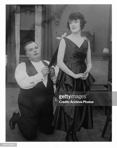 Roscoe 'Fatty' Arbuckle holds Mabel Normand by her dress in a scene from the film 'Mabel And Fatty's Married Life', 1915.