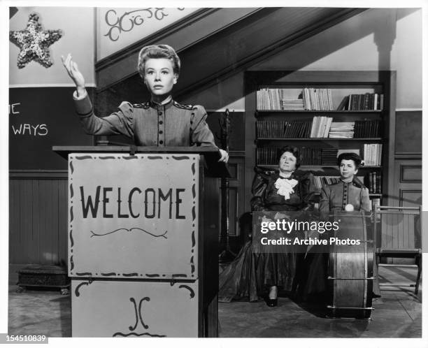 Vera-Ellen stands at a podium in front of Marjorie Main and Alice Pearce in a scene from the film 'The Belle Of New York', 1952.