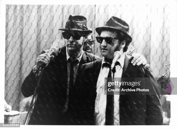Dan Aykroyd holds a microphone standing next to John Belushi in a scene from the film 'The Blues Brothers', 1980.