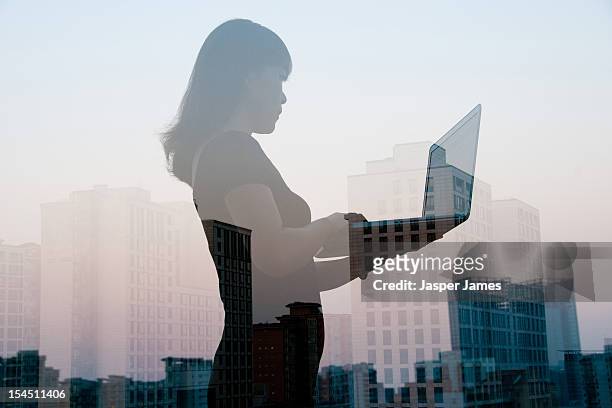 double exposure of woman using laptop and city - double exposure technology stock-fotos und bilder