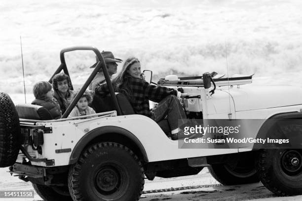 American fashion designer Ralph Lauren and his wife, therapist Ricky Lauren, sit in a jeep on the beach with their children, David, Andrew, & Dylan,...