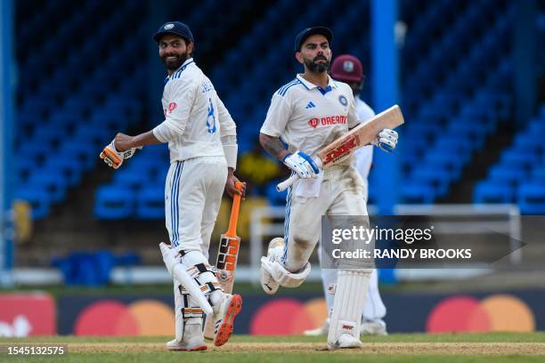 Ravindra Jadeja and Virat Kohli , of India, celebrate their 100 runs partnership on the first day of the second Test cricket match between India and...