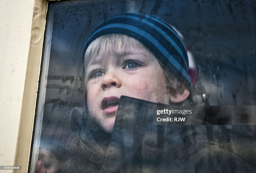 Boy Looking Out Of Window