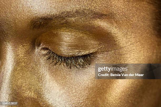 close up of golden  closed eye. - body paint 個照片及圖片檔