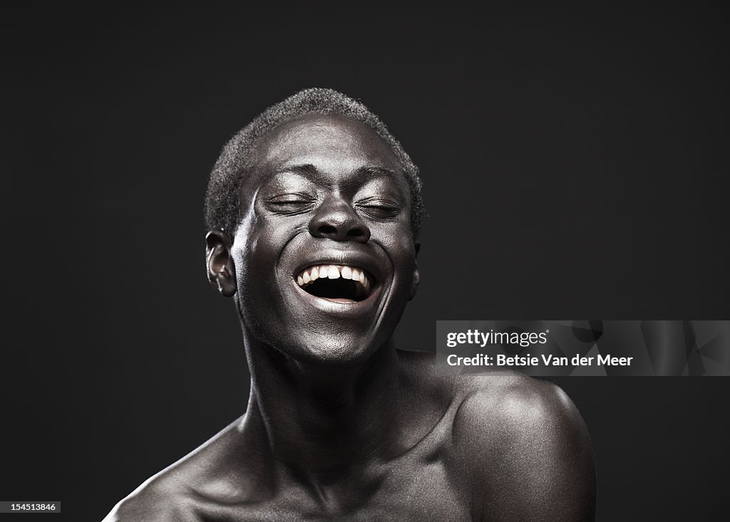 Portrait of young black man laughing.