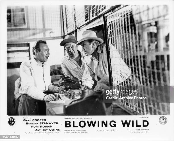 Ward Bond and Gary Cooper talk to a man in a scene from the film 'Blowing Wild', 1953.