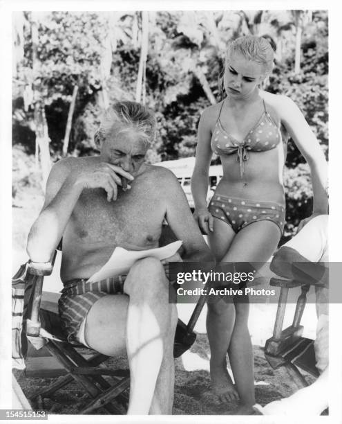 John Huston with Sue Lyon in between shots from the film 'The Night Of The Iguana', 1964.