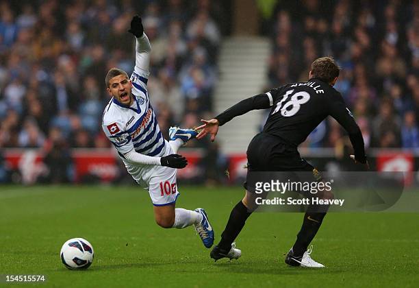 Adel Taarabt of Queens Park Rangers is tripped by Phil Neville of Everton during the Barclays Premier League match between Queens Park Rangers and...