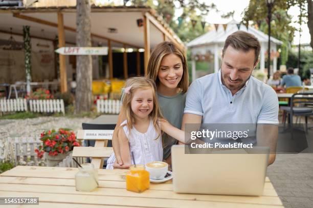 family using laptop at sidewalk cafe - coffee shop couple stock pictures, royalty-free photos & images