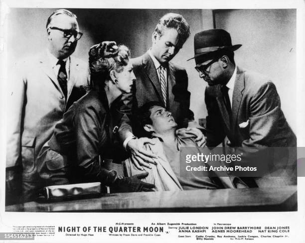 Agnes Moorehead, Dean Jones, and group standing over sitting man in a scene from the film 'Night Of The Quarter Moon', 1959.